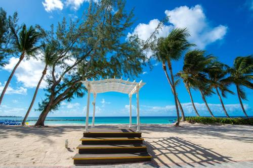 a wedding arch on a beach with palm trees at Turtle Beach, a Tribute Portfolio All Inclusive Hotel in Christ Church
