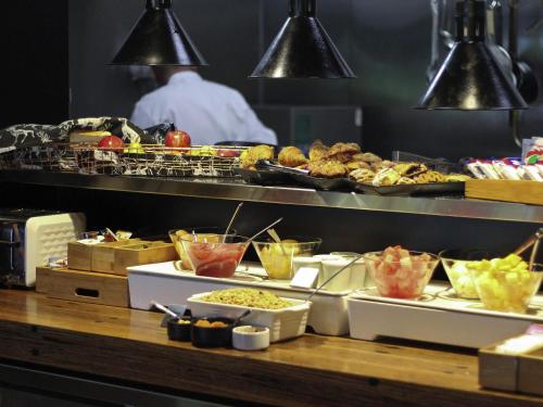Una línea de buffet con diversos alimentos y un chef. en Mercure Launceston, en Launceston