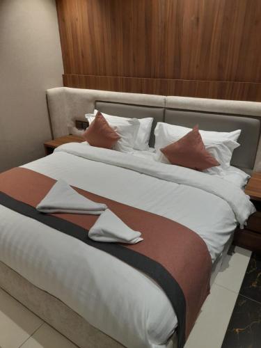 a large bed with white sheets and pillows at إيفان للشقق المخدومة المروج in Riyadh