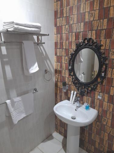 a bathroom with a sink and a mirror at إيفان للشقق المخدومة المروج in Riyadh
