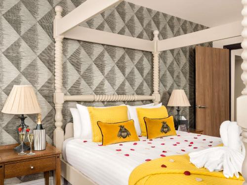 a bedroom with a white bed with yellow pillows at Mercure Doncaster Centre Danum Hotel in Doncaster