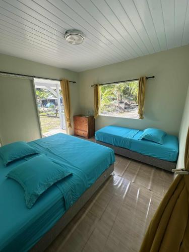 ボラボラにあるTe Fati Faniu Lodgeのベッド2台と窓のある寝室