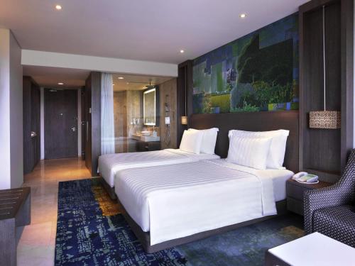 a bedroom with a large white bed and a couch at Grand Mercure Jakarta Kemayoran in Jakarta