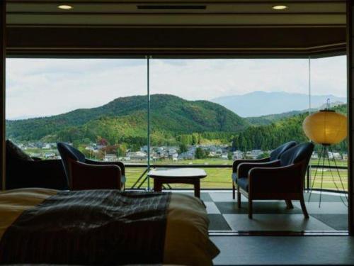 a bedroom with a large window with a view of a mountain at Shiratamano Yu Kahou in Shibata