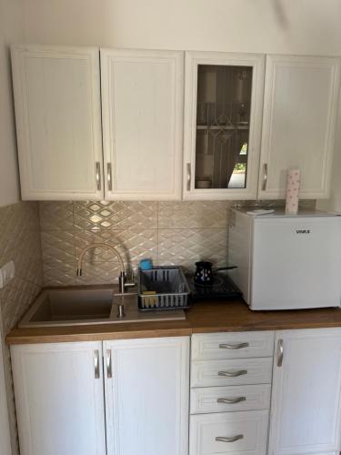 a kitchen with white cabinets and a sink and a microwave at Central3 in Pančevo