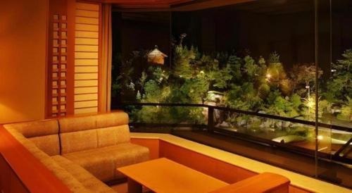 a living room with a couch and a large window at Shiratamano Yu Kahou in Shibata