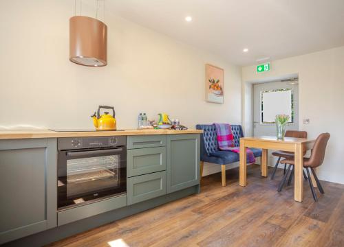 a kitchen with a stove and a table with chairs at Castlestone Holiday Cottages & Townhouses in Naas
