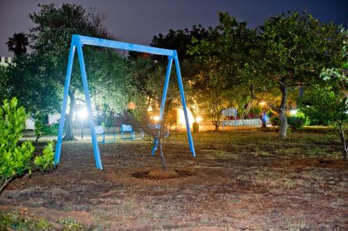 a blue swing set in a park at night at Dolphin Apartments in Frangokastello