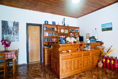 a man sitting at a counter in a room at Dolphin Apartments in Frangokastello
