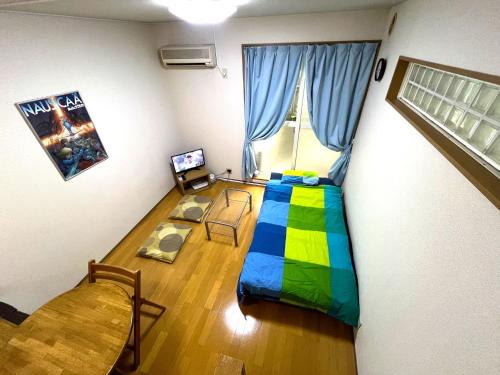 a room with a bedroom with a bed and a table at About a 3minute walk from JR Nishi-Ogikubo St, in Kichijōji