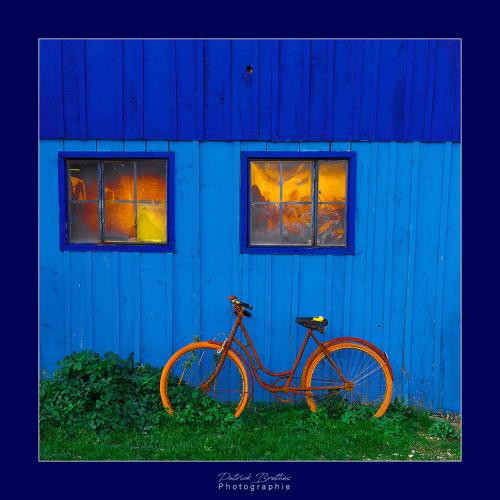 a bike parked in front of a blue building at Hotel Le Coureau in Saint-Trojan-les-Bains