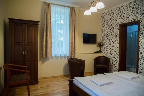 a room with a bed and a table and a window at Althaus Vendégház in Németkér