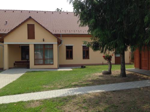 a house with a tree in front of it at Althaus Vendégház in Németkér