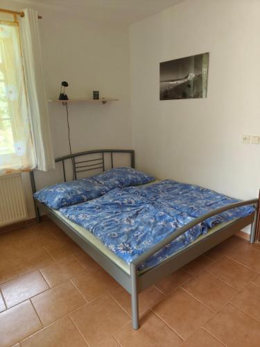 a bed with a blue comforter in a bedroom at Apartman Janky 299 in Trutnov