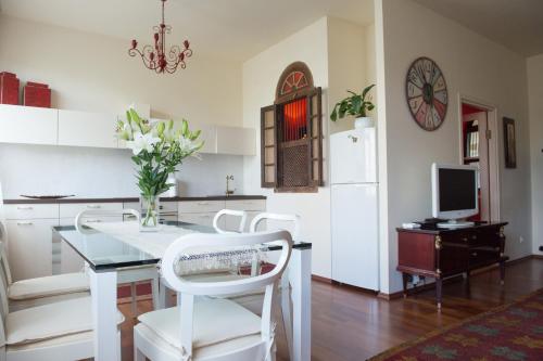 a kitchen with a white table and white chairs at Rävala Boulevard Apartment in Tallinn
