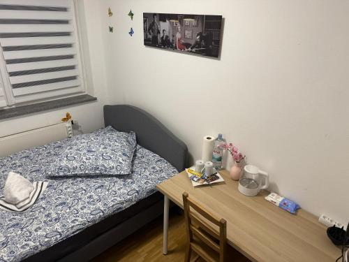 a small bedroom with a bed and a wooden table at München Haus-Centrum-Messe-Oktoberfest -7-24 CHECKIN in Munich