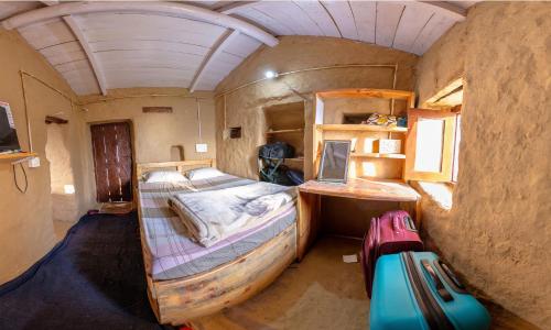 a small room with a bed and a desk at Orchard Oasis Homestay in Mukteswar