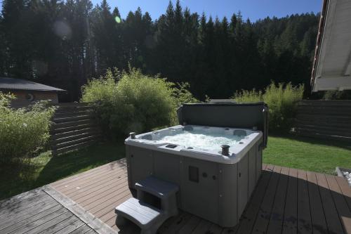 a hot tub sitting on a deck in a yard at Chalet Vertpheny Spa & Terrasse à 500m du Lac de Gérardmer in Gérardmer