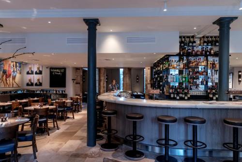 a bar in a restaurant with tables and chairs at Old Bank Hotel in Oxford