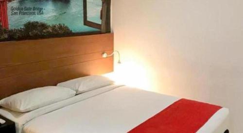 a bedroom with a bed with a red and white blanket at Hotel Zamburger Bangsar (Previously Koptown Hotel Bangsar) in Kuala Lumpur
