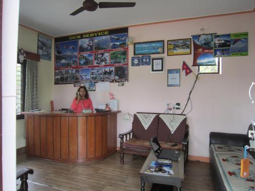 a woman sitting at a counter in a waiting room at New Annapurna Guest House in Pokhara