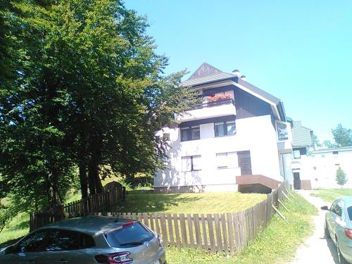 ein Haus mit einem davor geparkt in der Unterkunft Art Apartman in Plitvička Jezera