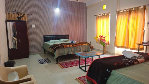 a bedroom with a bed and a table in it at Nilachal Homes in Guwahati