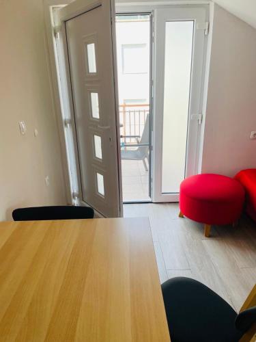 a living room with a table and a red chair at D-Spot apartments Pišta in Zaostrog