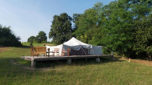 Tienda con 2 sillas y mesa en un campo en Tamana Tuquet Tentes Mauritannienne, en Bergerac