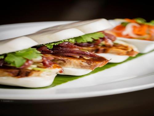 a white plate with three sandwiches on it at Ibis Styles Singapore On Macpherson in Singapore