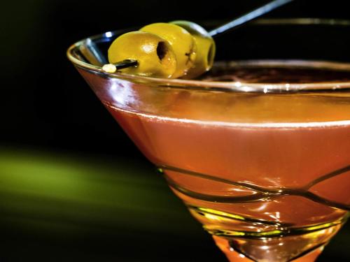 a martini glass filled with a drink with olives at Ibis Styles Singapore On Macpherson in Singapore