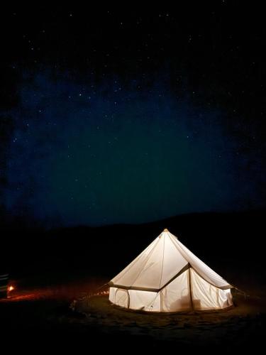 una tienda blanca bajo un cielo estrellado por la noche en Night Stars Camp, en Badīyah