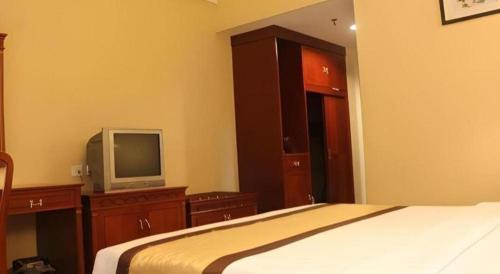 a bedroom with a bed and a tv on a dresser at MB Hotel in Tawau
