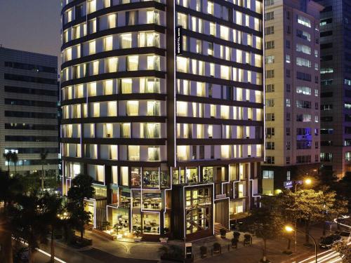 a tall building with many windows at night at Novotel Suites Hanoi in Hanoi