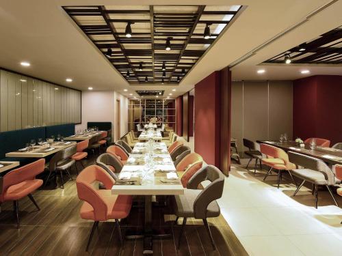 a dining room with long tables and chairs at Novotel Suites Hanoi in Hanoi