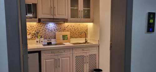 a kitchen with white cabinets and a sink at Studio for rent Addis Ababa, KMAN in Addis Ababa