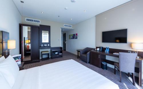 a hotel room with a bed and a desk at Premier Inn Doha Airport in Doha