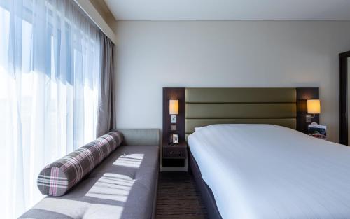 a bedroom with a bed and a large window at Premier Inn Doha Airport in Doha