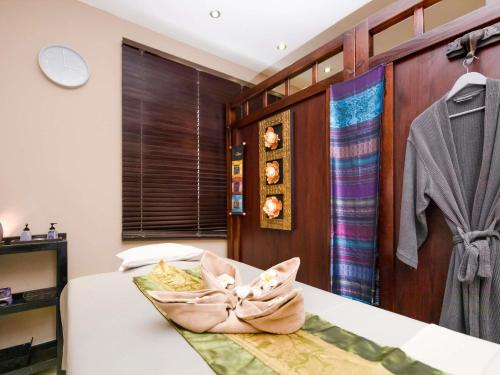 a bedroom with a bed with a towel on it at Ibis Styles Accra Airport in Accra