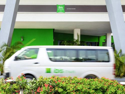 a white van parked in front of a building at Ibis Styles Accra Airport in Accra
