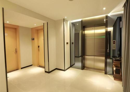 a hallway with elevators in a building with lights at Borrman Hotel Zhuhai Gongbei Port Fuhuali Light Rail in Zhuhai