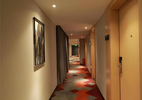 a hallway with a long hallway with a tile floor at Borrman Hotel Zhuhai Gongbei Port Fuhuali Light Rail in Zhuhai