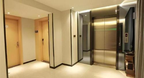 a hallway with elevators in a building at Borrman Hotel Zhuhai Gongbei Port Fuhuali Light Rail in Zhuhai