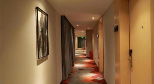 a hallway with a long corridorngthngthngthngthngthngthngthngthngthngth at Borrman Hotel Zhuhai Gongbei Port Fuhuali Light Rail in Zhuhai