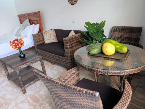 a living room with a table and chairs and a couch at Oslo Gardens Airport in Entebbe