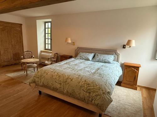 a bedroom with a bed and a table and a chair at Auberge du Vieux Brancion in Martailly-lès-Brancion