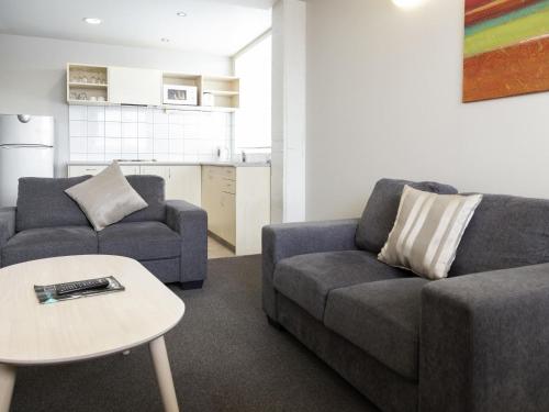 a living room with two couches and a table at Ibis Styles Invercargill in Invercargill