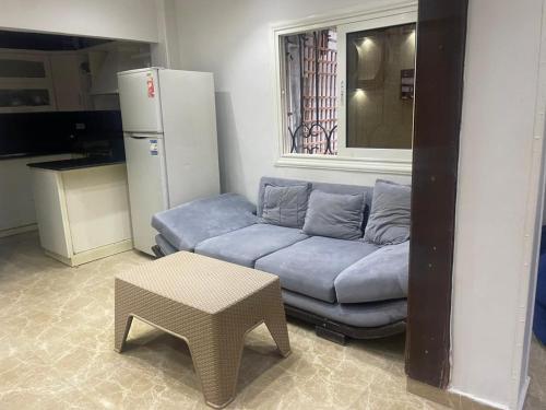 ein Wohnzimmer mit einem blauen Sofa und einem Tisch in der Unterkunft Leila Home Garden - Maamourah Beach in Alexandria