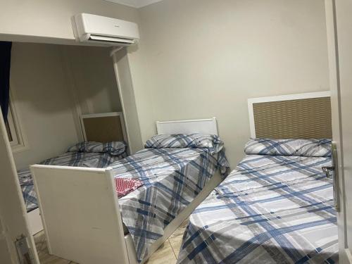 ein Zimmer mit zwei Betten und einem Spiegel in der Unterkunft Leila Home Garden - Maamourah Beach in Alexandria