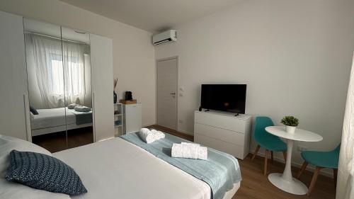 a bedroom with a bed and a table and a tv at Framira House - Elegant Room tra Centro e Fiera in Bologna